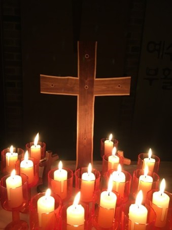 성당에서-십자가앞에-촛불이-수십개-켜져있는-모습