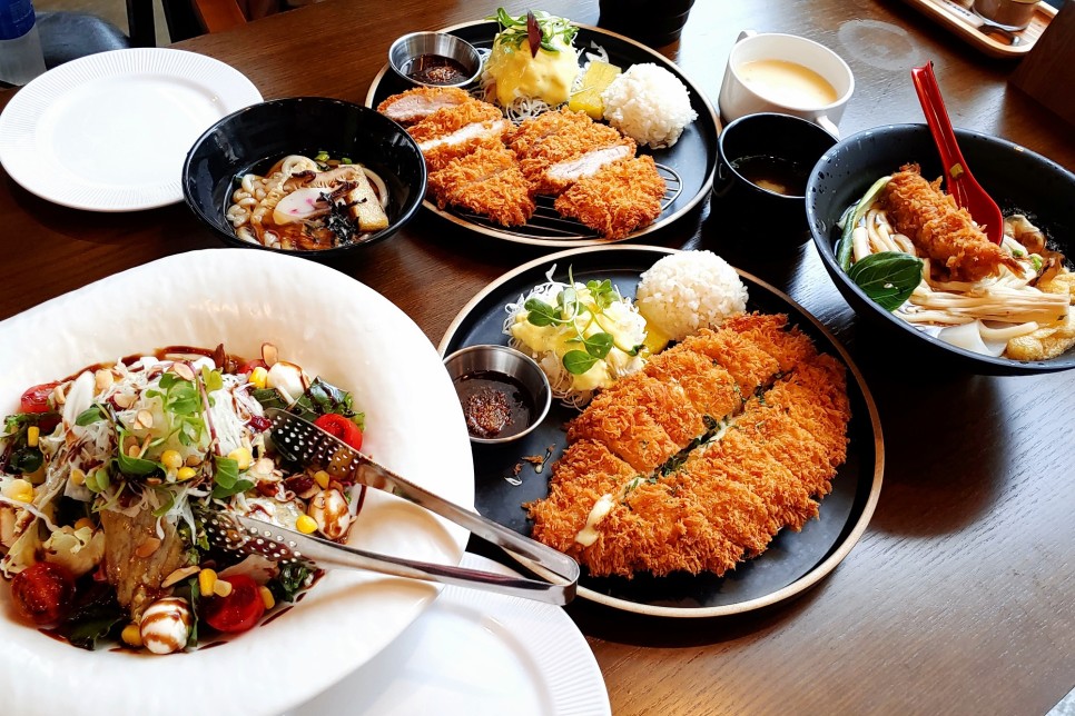 돈까스, 샐러드, 돈까스우동 등이 상에 놓인 모습