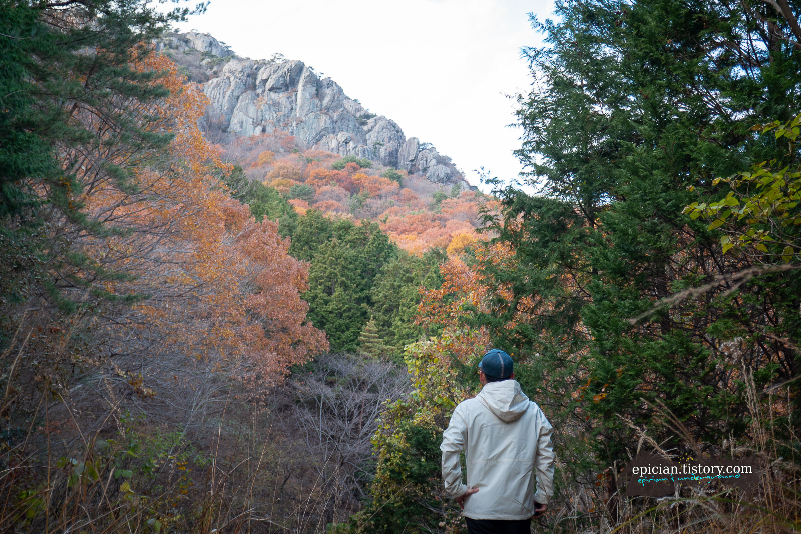 커다란 암릉 아래로 울긋불긋한 단풍이 보이는 풍경