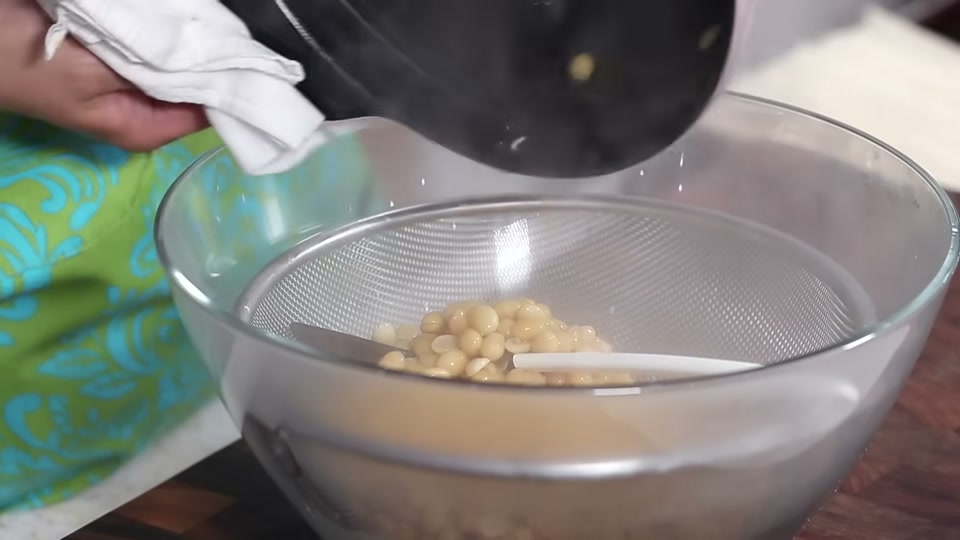 체에 밭쳐 삶은 콩과 콩물을 분리하는 장면