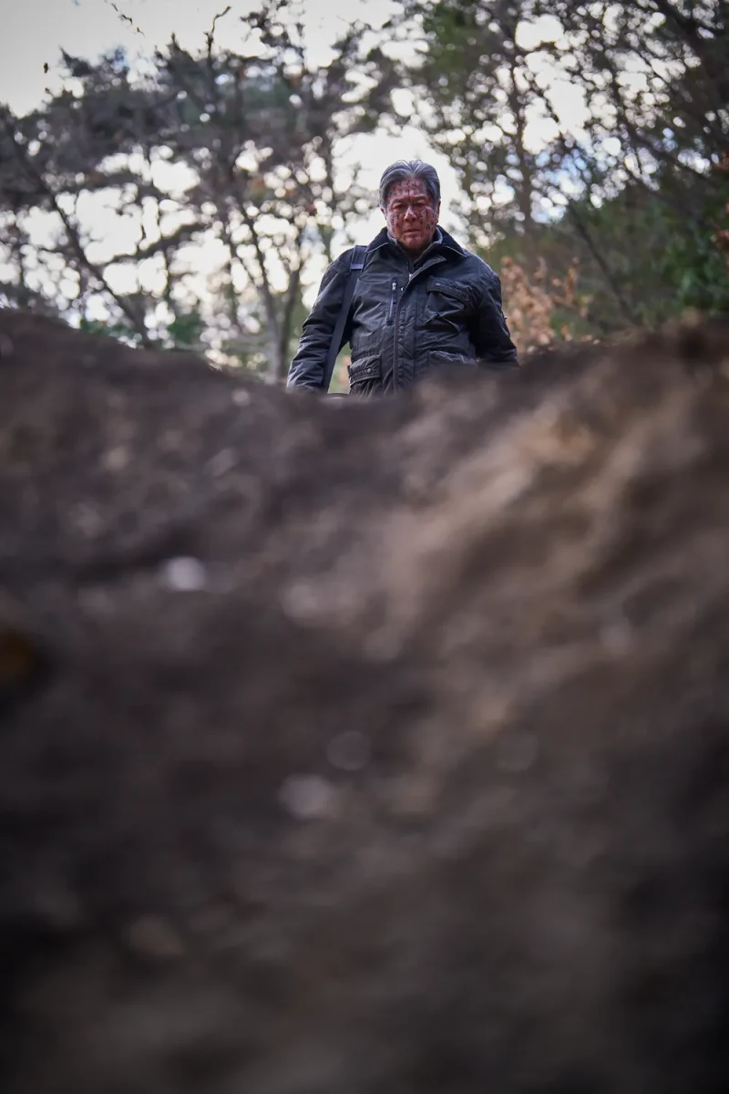 파묘에서 얼굴에 이상한 문자를 새기고 서 있는 최민식