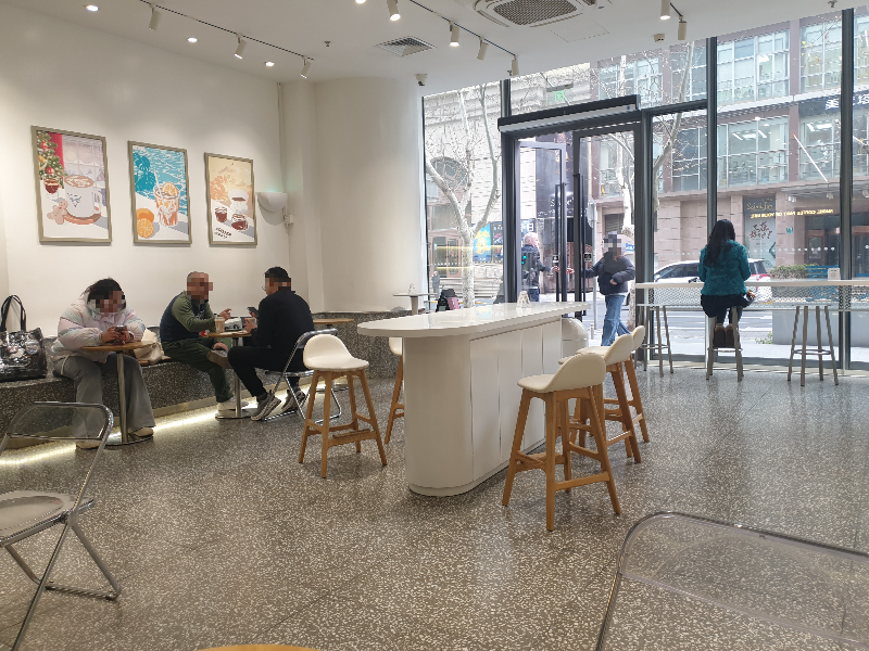 흰 벽면과 테라조 바닥. 중앙 아일랜드 테이블이 중심을 잡아준다.