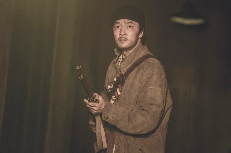 빵모자에 장총을 들고 경계를 서고 있는 넷플릭스 경성크리처에서 윤중원을 연기하는 배우 조한철