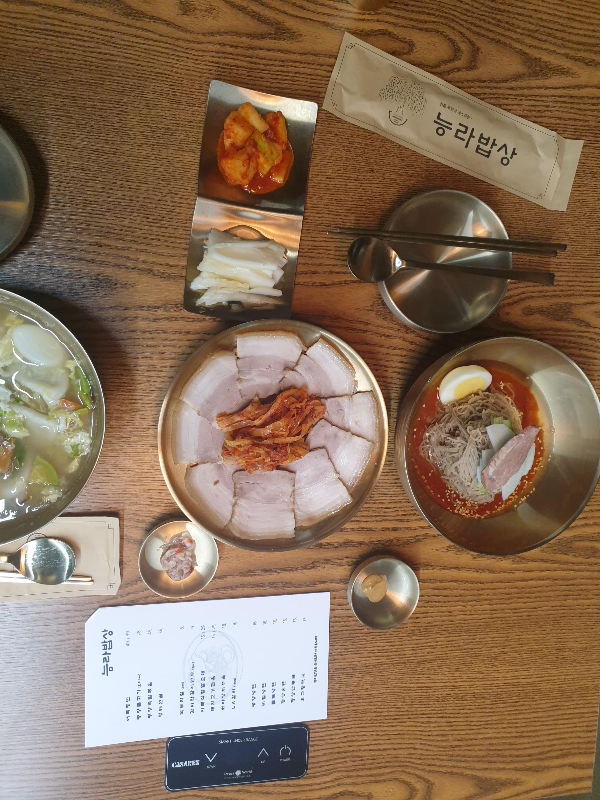 주문한 만둣국, 편육, 비빔냉면이 가운데 놓여있다.