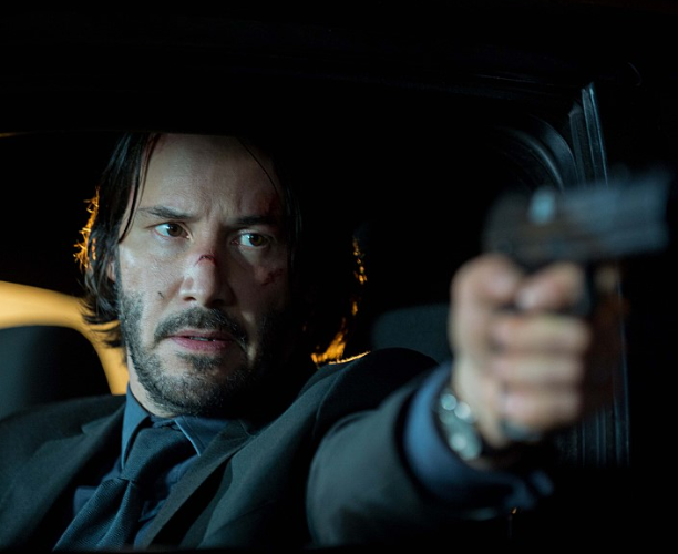 영화 주인공 존윅 이 권총을 겨누고 있는 모습