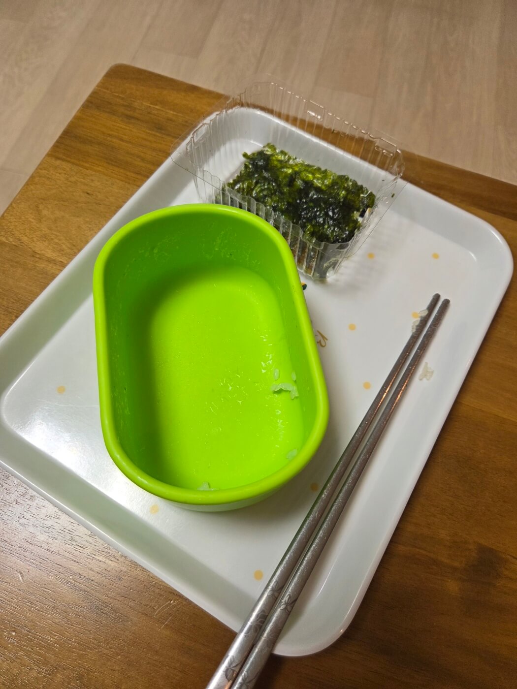 조미김으로 밥 한 그릇을 뚝딱 비워낸 빈 초록색 그릇과 젓가락이 놓인 쟁반