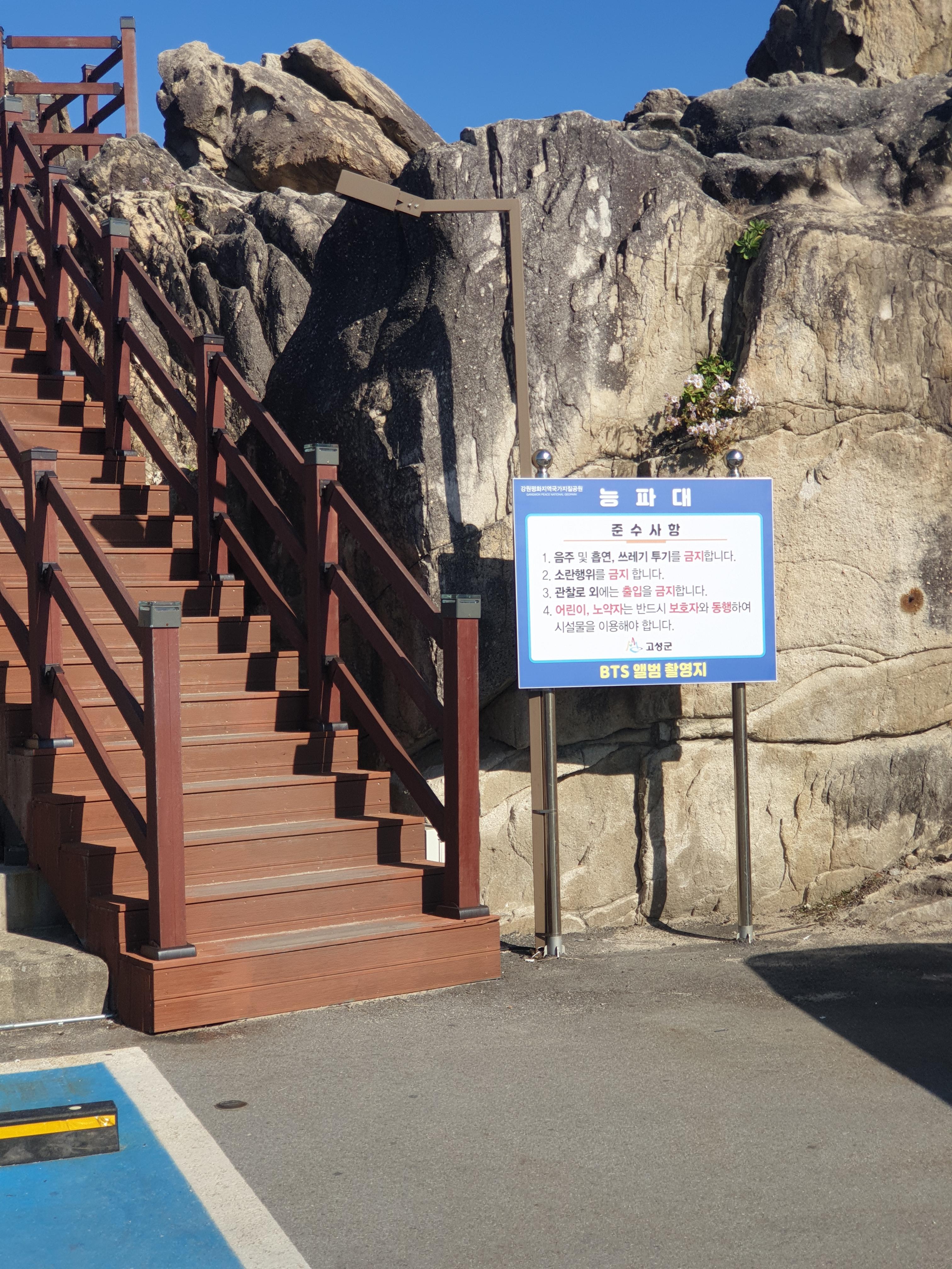 바위 사이로 데크로 만든 계단이 보인다. 계단 입구에 준수 사항 팻말이 설치되어 있다.