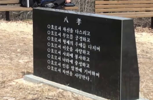 벤치 앞에 놓인 &lsquo;八孝&rsquo; 비석