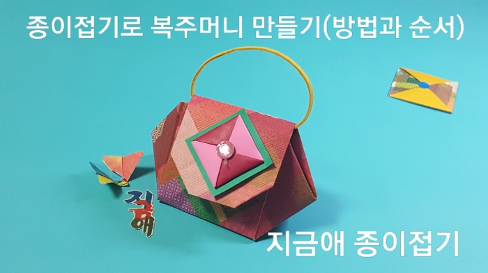 종이접기로 만든 복주머니 가방 모양입니다.