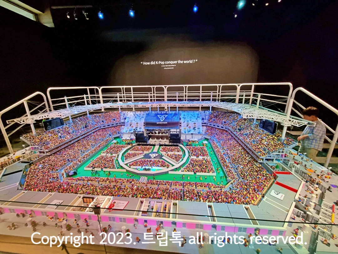 브릭으로 만든 지붕이 있고 단차가 있는 의자가 빼곡히 들어찬 세븐틴 콘서트장