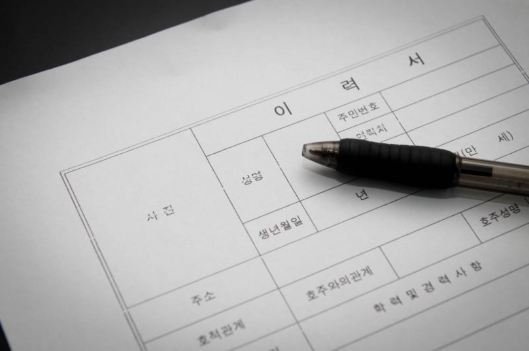 이력서와 펜이 놓여있다.