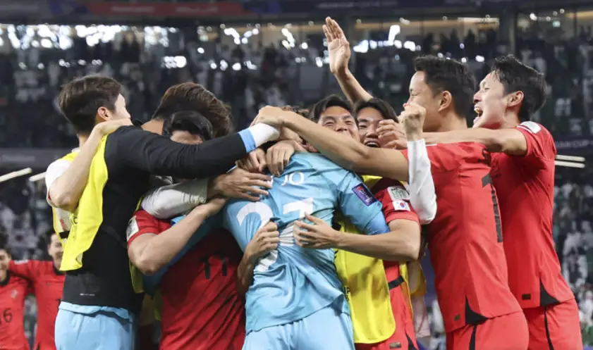 호주전전- 파란유니폼을 입은 조현우를 빨간유니폼을 입은 축구 대표팀들이 몰려와 전체가 안고있는 모습