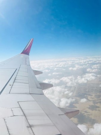 비행기-창문-밖으로-날개와-푸른하늘-하얀-구름이-솜처럼-보이는-모습