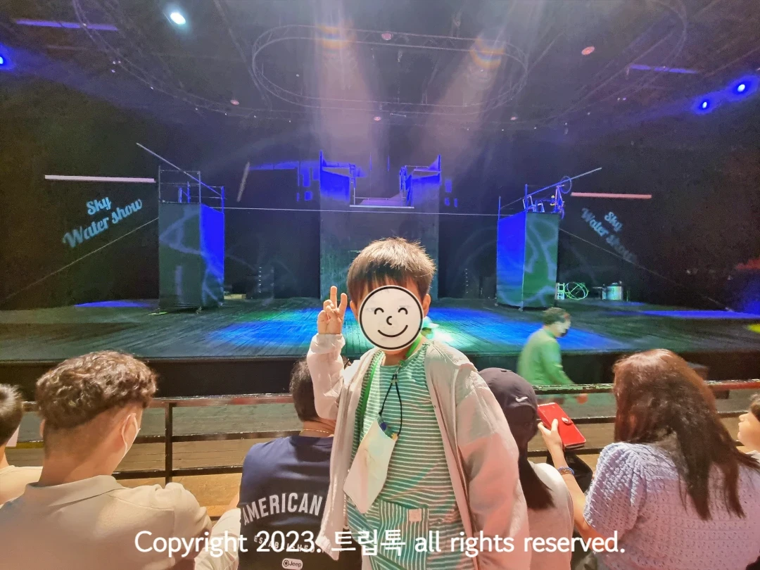 기다란 봉이 설치되 된 무대를 배경으로 서있는 아이