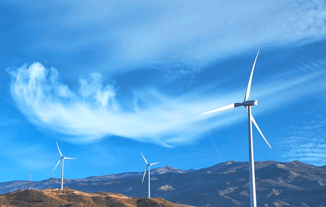 파란 하늘에 옅은 하얀색 구름이 깔려있다. 땅에는 하얀색 풍향게가 여러개 돌고 있다.