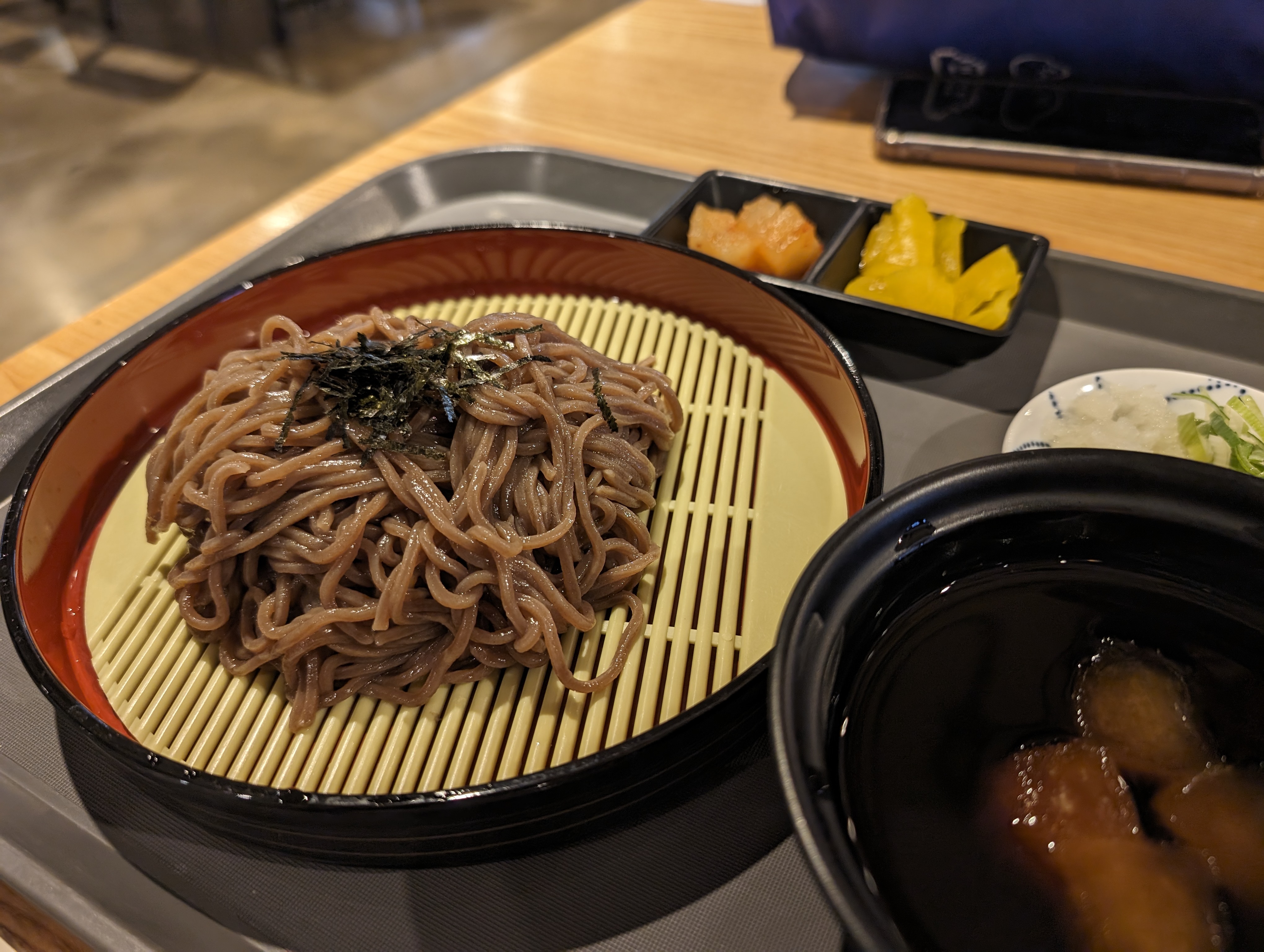 김가루가 올라간 냉모밀. 밑반찬으로 깍두기와 단무지가 있다.