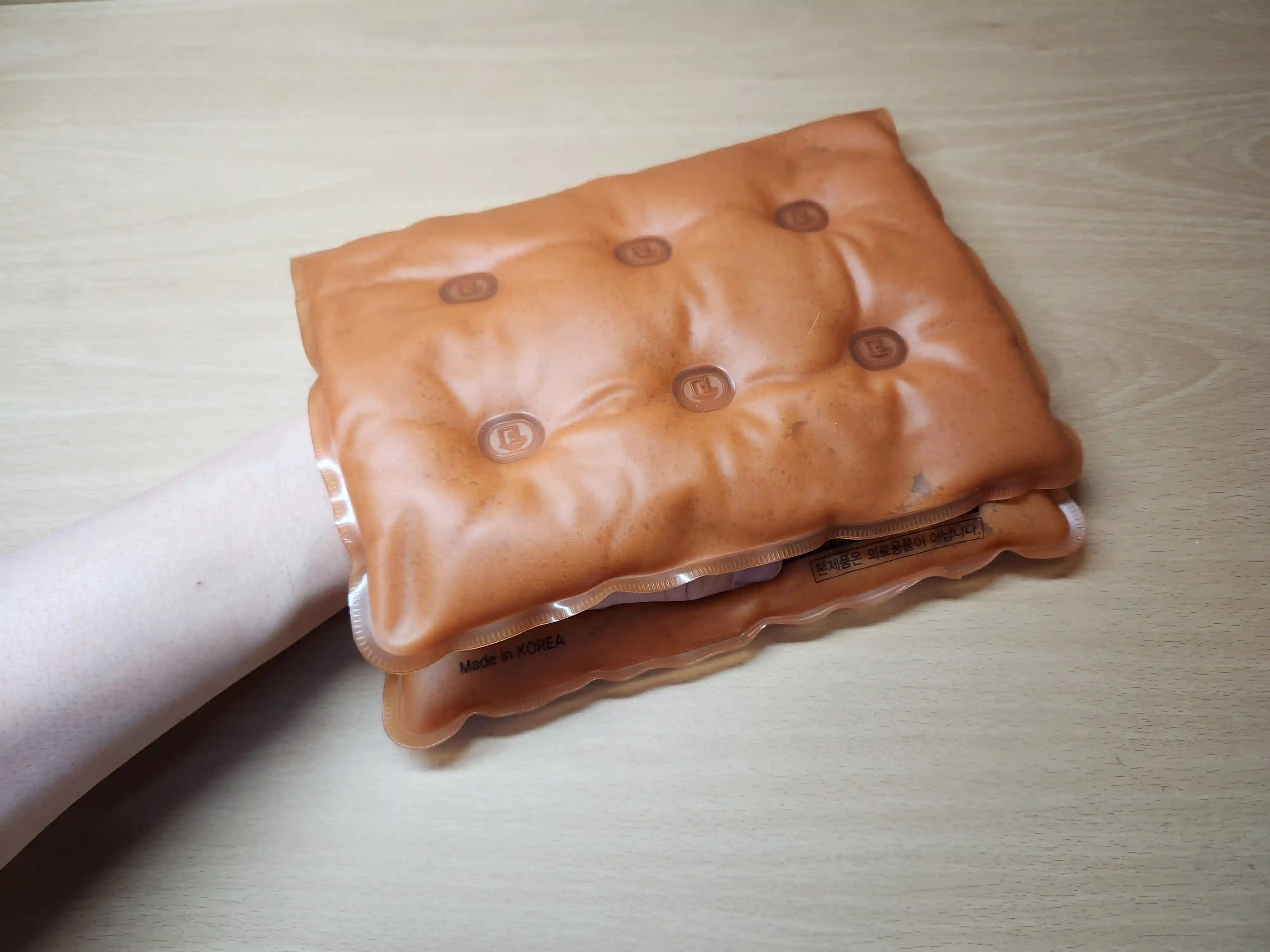 찜질팩을 접어 왼손을 넣고 찜질하는 이미지