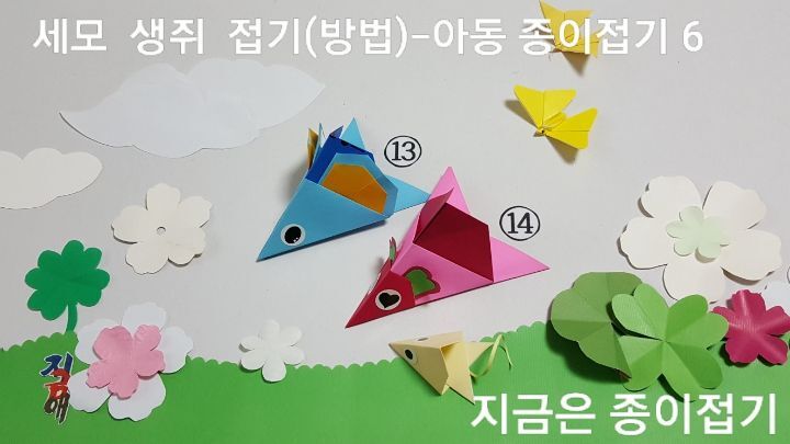 세모 생쥐 접기 방법 중 몸통 접기에 귀 붙인 파란쥐와 얼굴 접기를 하여 붙인 핑크색 쥐. 파란쥐 얼굴 대신 아기쥐로 만든 것이 풀밭에 있어요.