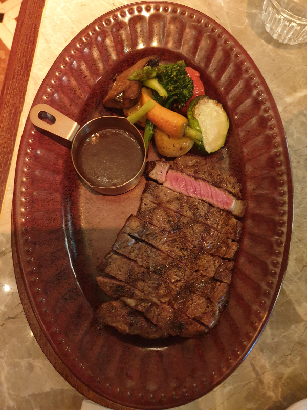 야채 가니시와 소스와 함께 나온 스테이크, 가운데 한 조각이 핑크색으로 먹음직스럽다.