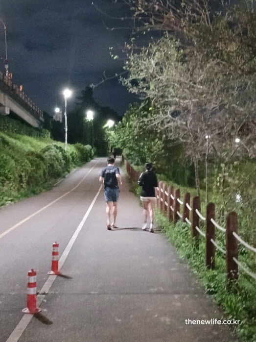 야간 강변 자전거도로에서 슬로우 조깅 방법으로 천천히 달리는 두 사람의 뒷모습
