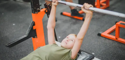 벤치프레스를 하고 있는 소년