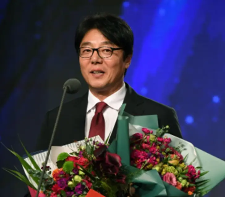 황선홍- 시상식에서 마이크를 앞에두고 양손가득 꽃다발을 들고 웃으며 말하는 황선홍