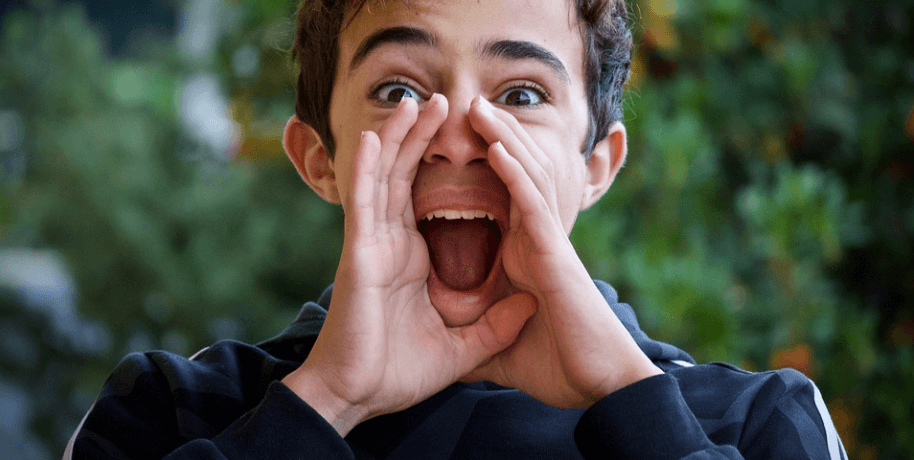 두손을 모아 고함을 지르고 있는 소년