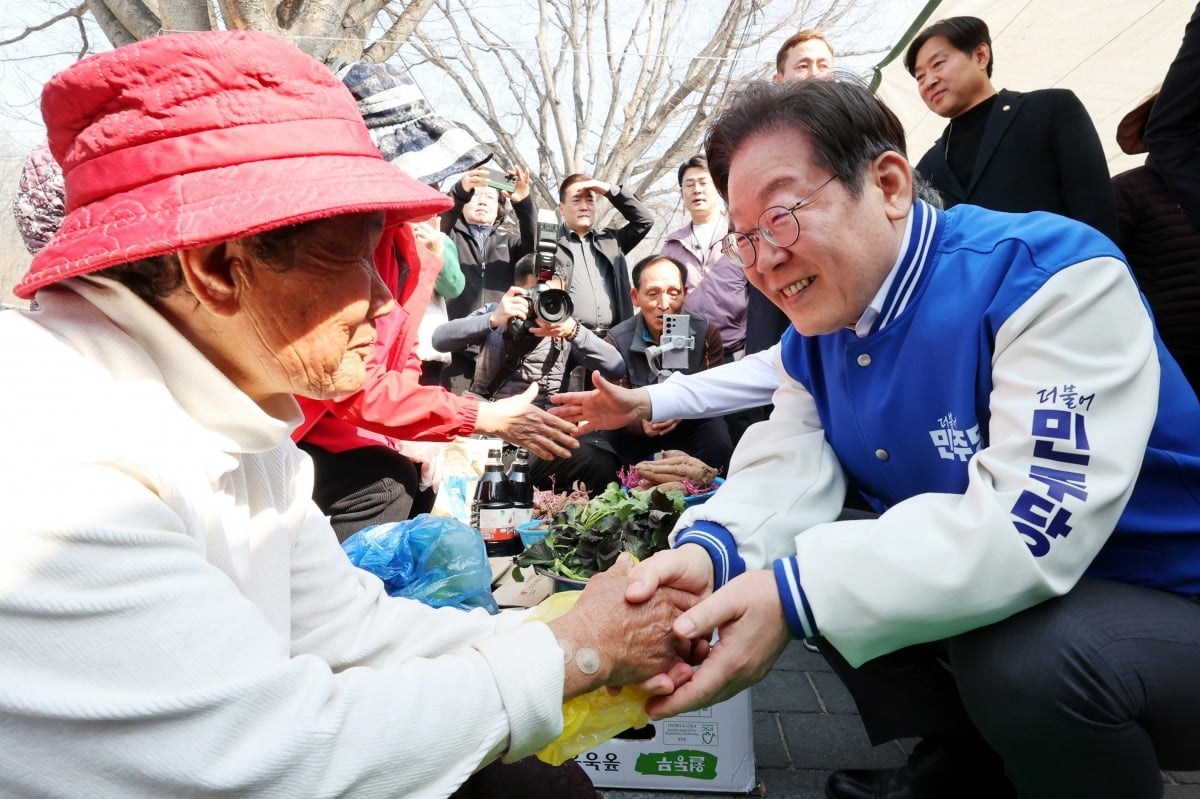더불어민주당 이재명 대표가 3월 22일 오전 전남 담양시장에서 이재종 후보 지원 유세를 하면서 상인과 악수를 하고 있다.