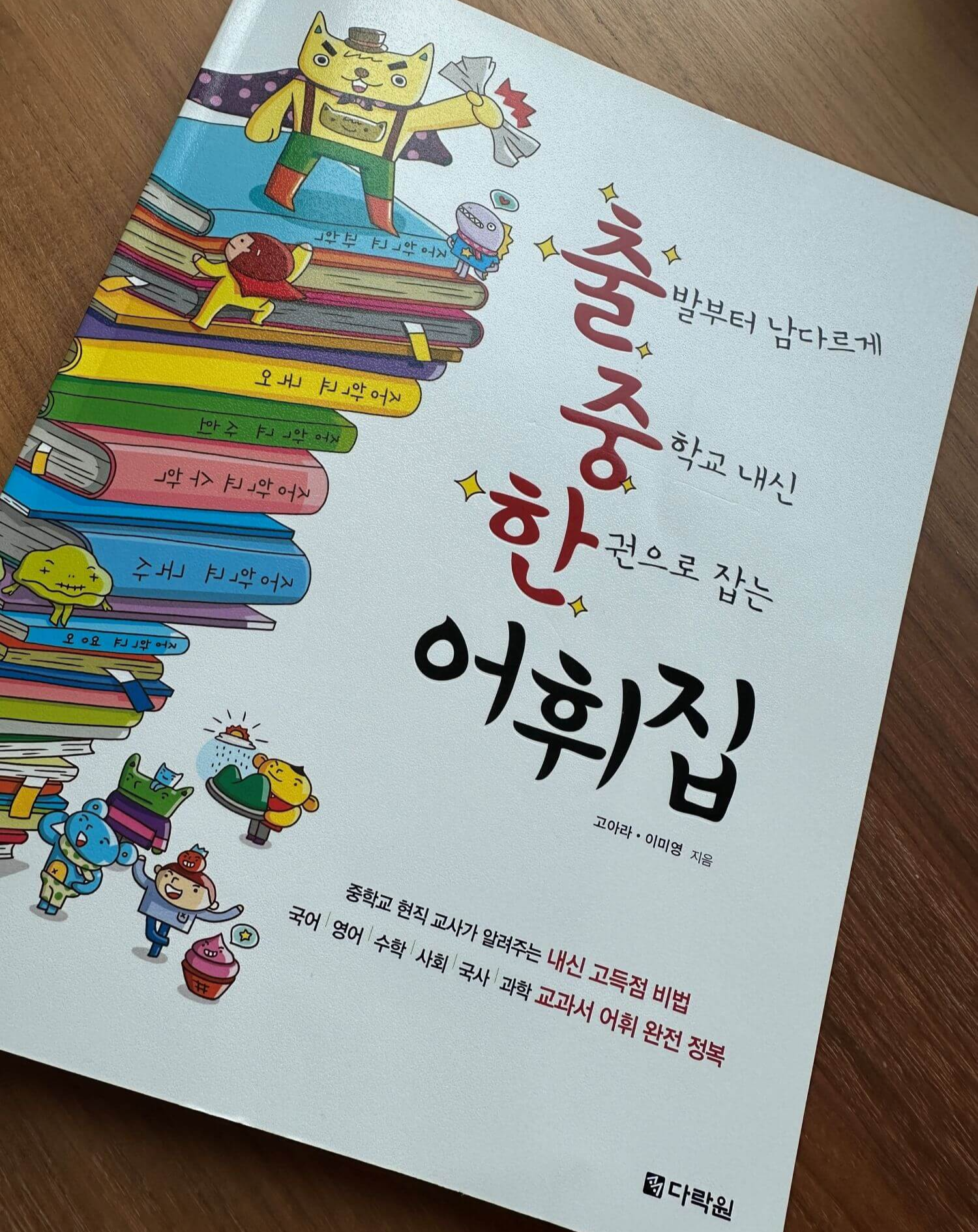 출중한-어휘집-책표지-과목별-교과서가-쌓여-있는-그림
