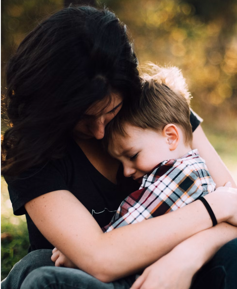 엄마의 품에 안겨 위로받는 어린 남자아이