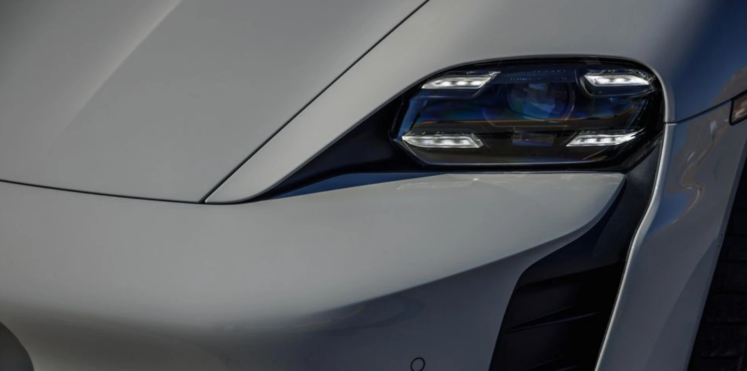 2024-포르쉐-타이칸-GTS의-헤드라이트가-보이고-있으며-희색차량에-각진-헤드라이트의-모습이-어울린다