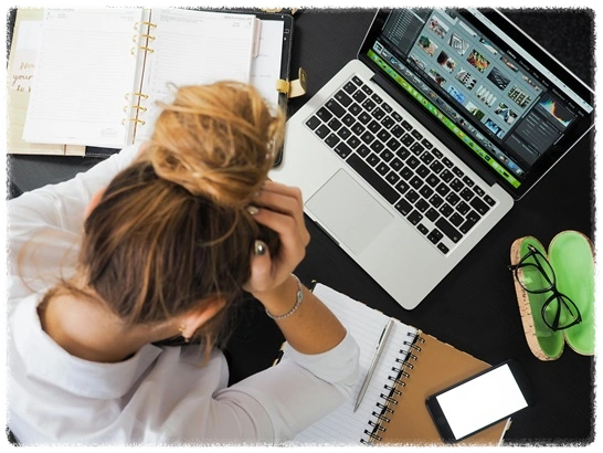 책상-위에-노트북이-있고-한-여자가-머리를-쥐어잡으며-좌절하는-모습
