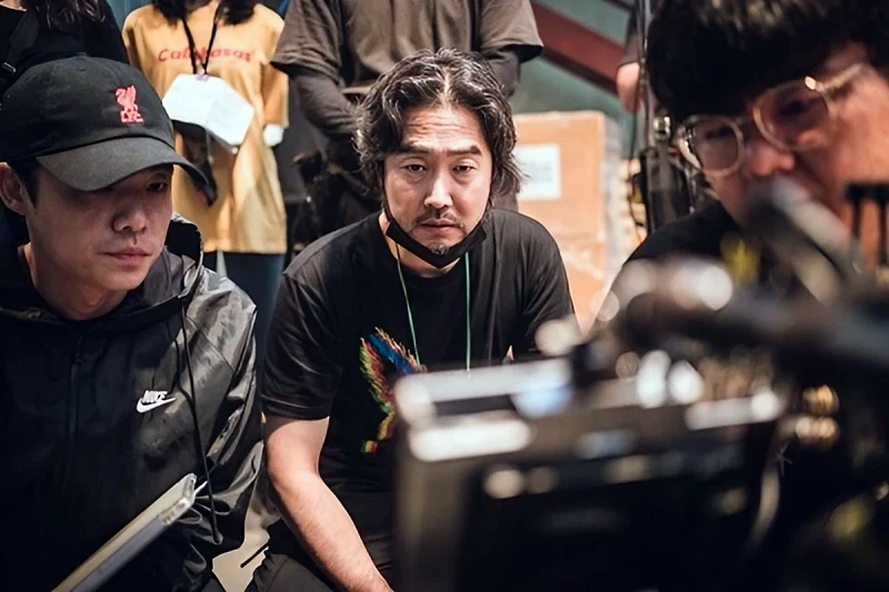 검은티에 앉아서 카메라를 보고 있는 킬러들의 쇼핑몰을 연출한 이권 감독