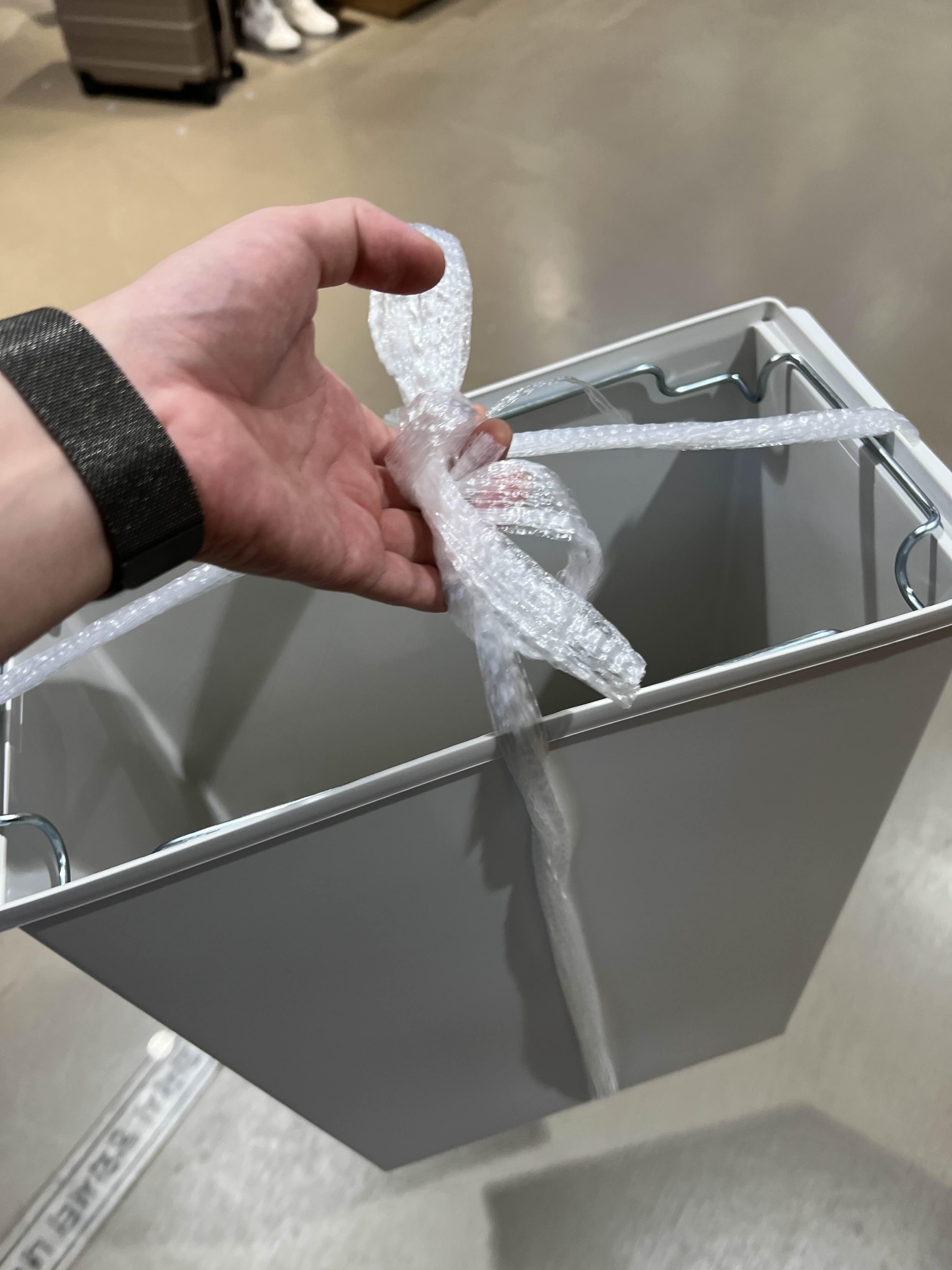 구매한 더스트박스(쓰레기통)을 노끈으로 묶어서 들고 있는 모습