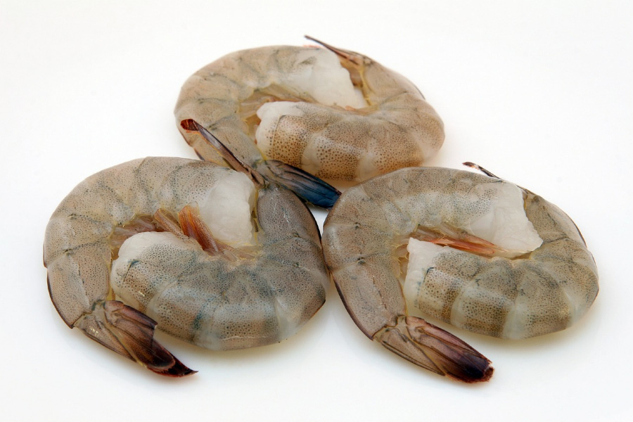 바다에서 채취를 한 새우를 깨끗하게 세척을 한 후에 머리를 떼어낸 것을 하얀 바닥 위에 2마리씩 서로 포갠 것을 3쌍 놓아두고 찍은 사진