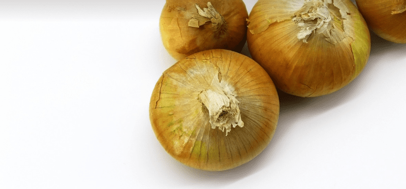 껍질이 벗겨지지 않은 양파 여러 개가 놓여 있다