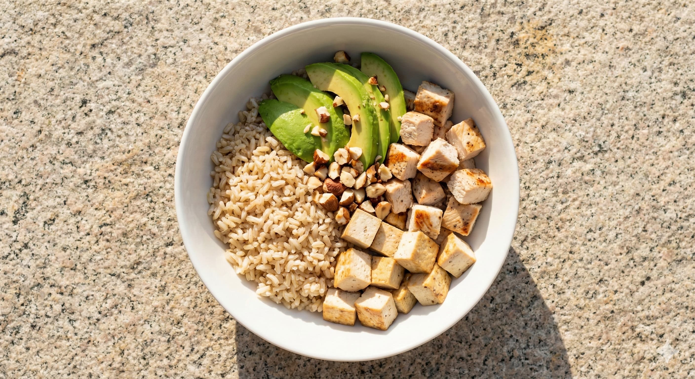 자연의 돌 위에 놓인 흰 접시, 탄수화물, 단백질, 지방이 완벽하게 균형 잡힌 건강한 부다 볼 식단 항공샷.