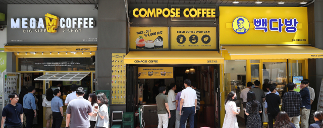 서울 시내에 위치한 저가 브랜드 커피 매장 앞에서 시민들이 줄지어 커피를 구매하고 있다.