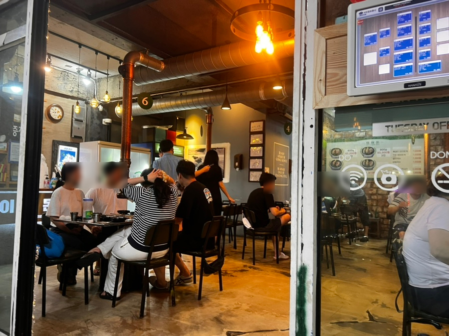 손님들로 가득 찬 이어돈 내부와 함덕 바다가 보이는 야외 좌석 모습