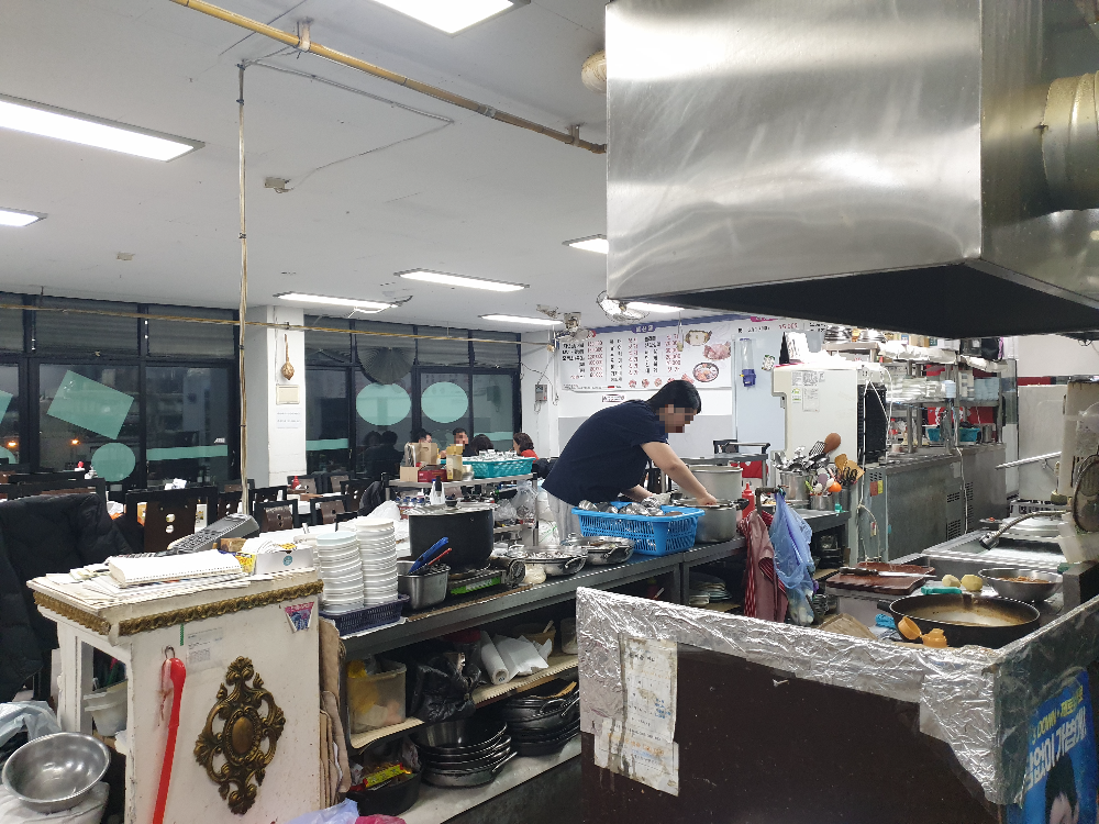 식당 내부 한 팀 손님이 있다. 직원 하나가 서빙 중이다.