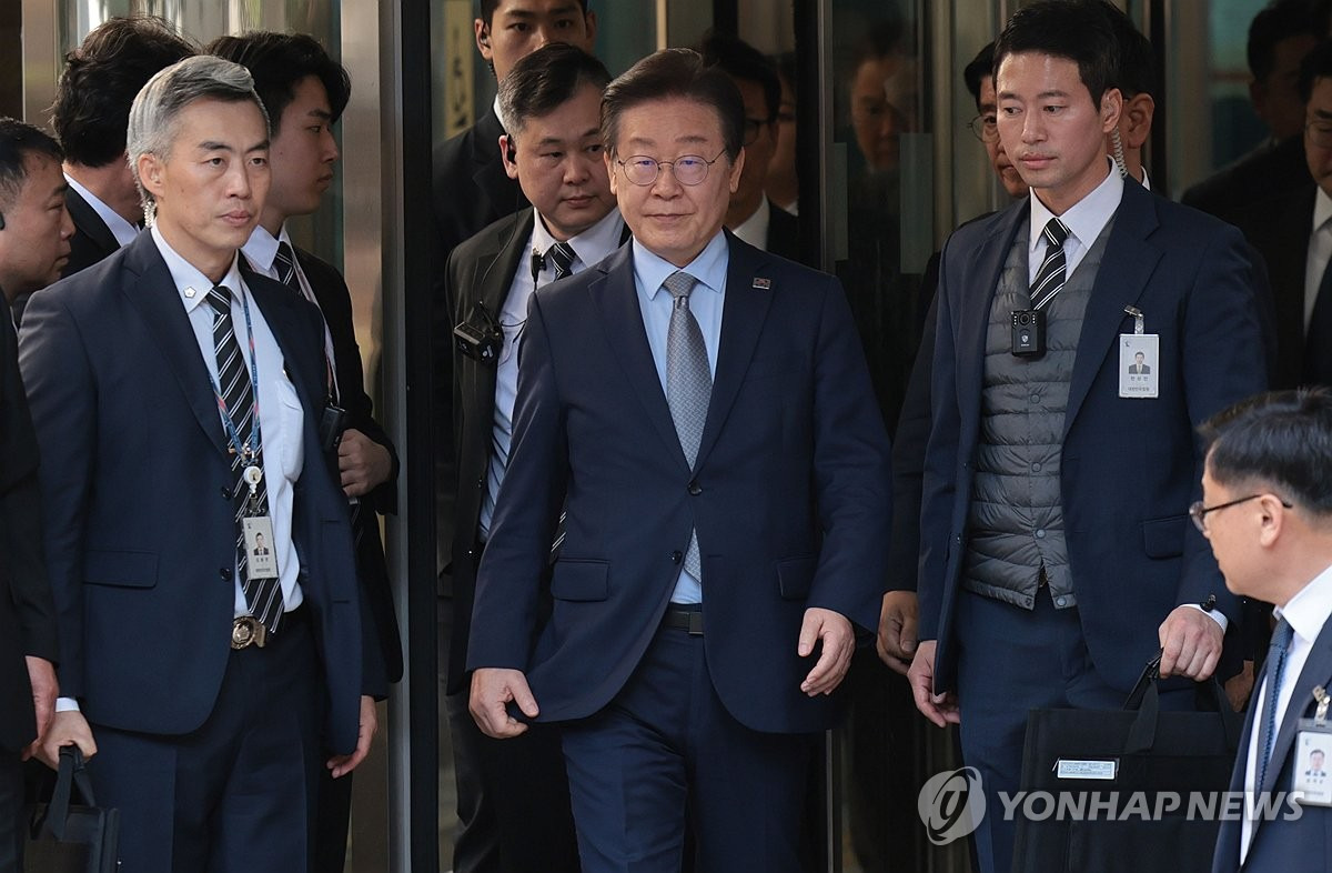 사람들 사이를걸어나오는 이재명 대통령 사진