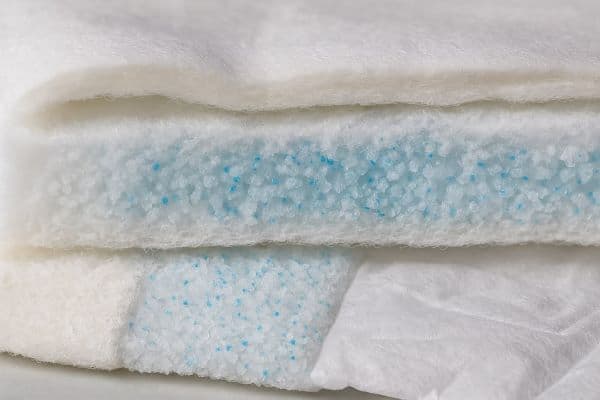 다층 구조의 기저귀 단면, 부드러운 탑시트, SAP가 포함된 흡수층, 방수 백시트의 질감과 기능