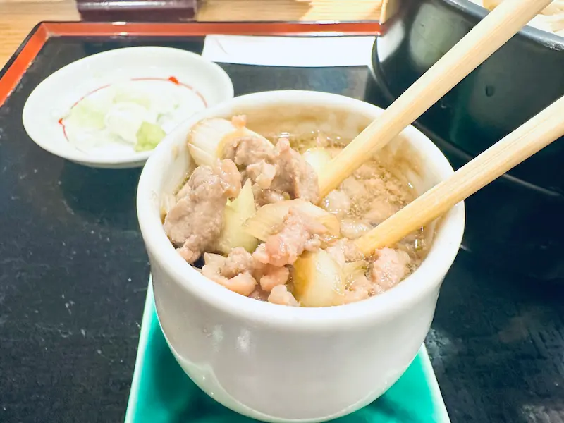 오리기름의 윤기가 흐르는 진하고 묵직한 간장 베이스 육수 속에 씹는 맛이 좋은 잘게 썬 오리고기 건더기가 듬뿍 담겨 있는 작은 쯔유 그릇 상세