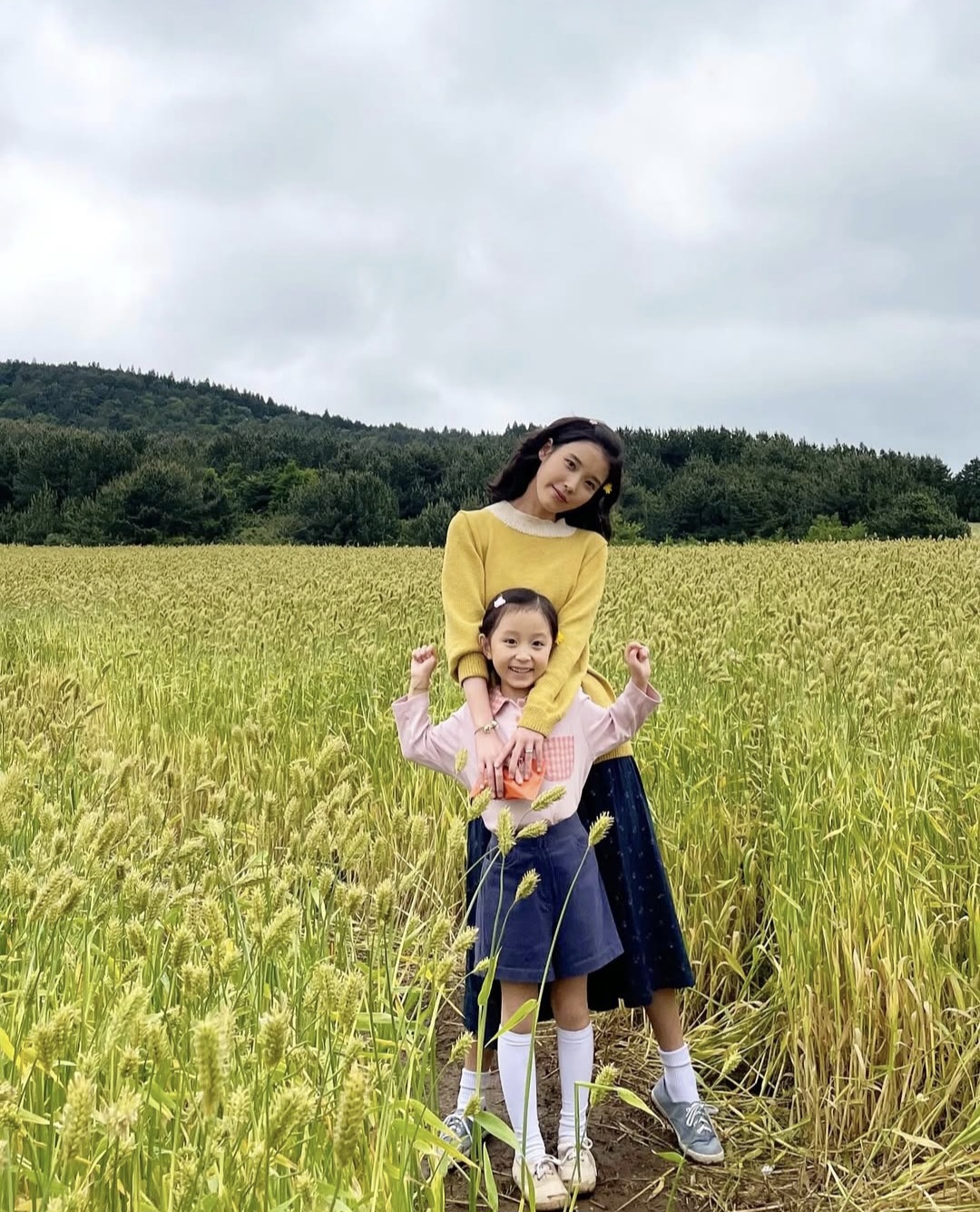 유채꽃밭에서 아이유와 아역배우가 함께 찍은 사진