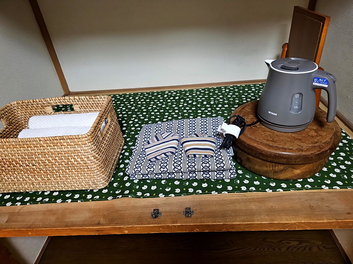 Coffee pot, yukata, and towels arranged in a Tamaki Ryokan room