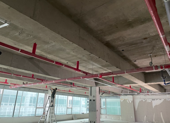 새로 짓는 건물에서 소방 스프링클러를 설치하고있는 작업자