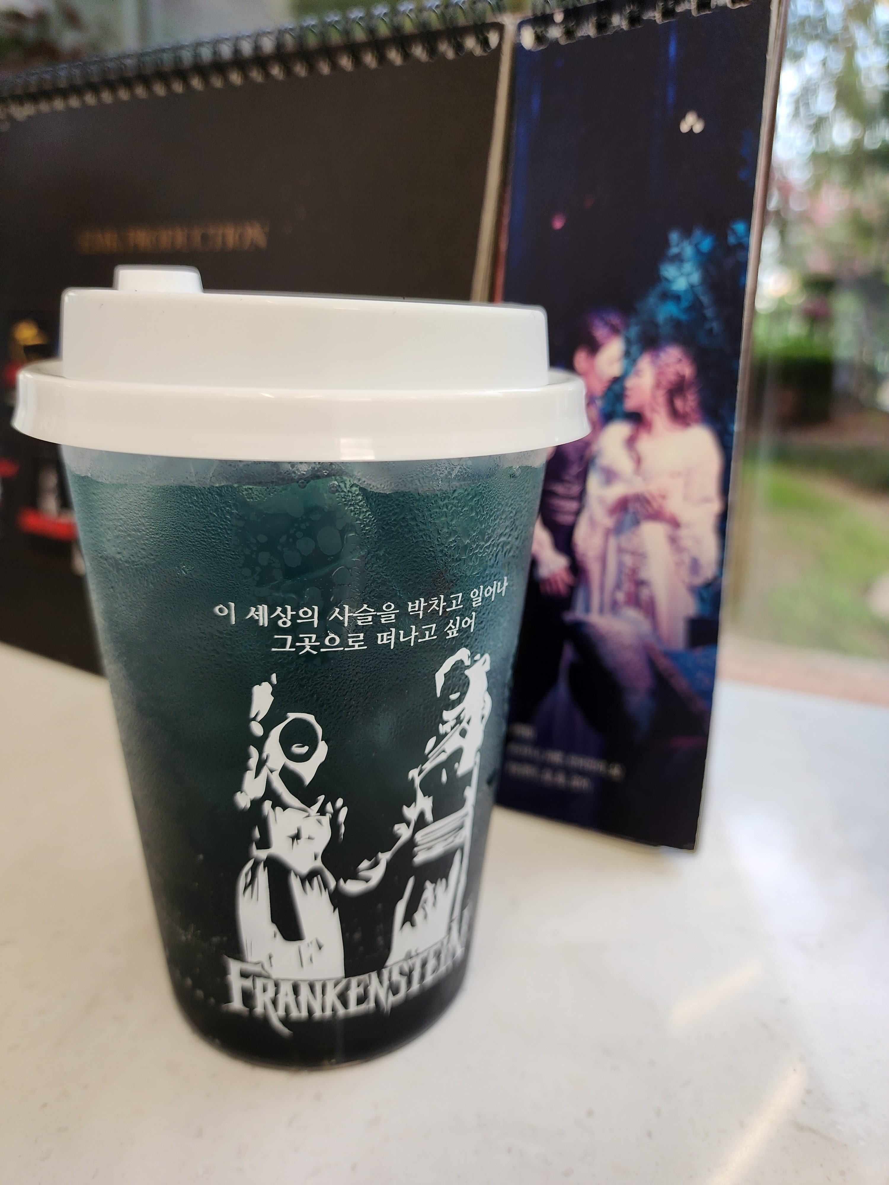 블루스퀘어 앞 드 블루 카페에서 프랑켄슈타인 특별 음료와 함께 제공하는 리유저블 컵 (그곳에는 까뜨린느와 괴물 그림)