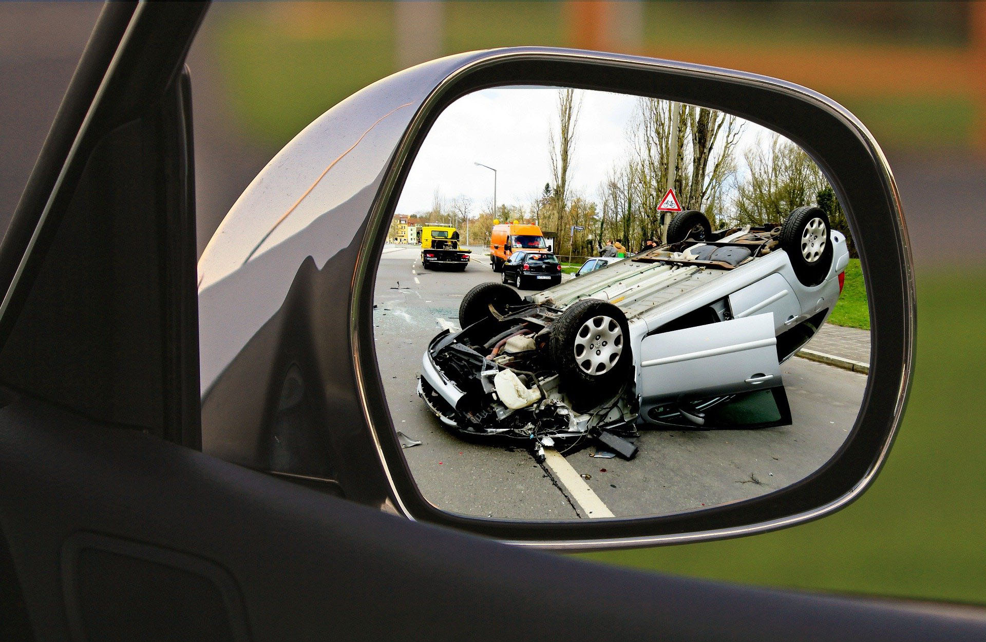 자동차 백미러를 통해 교통사고로 승용차가 뒤집힌 모습