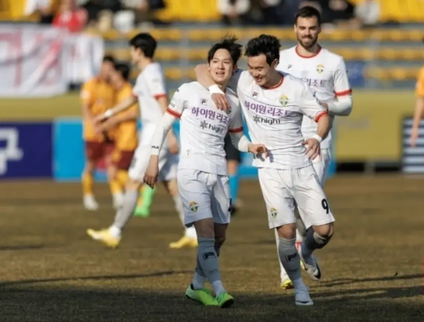 축구장 흰 유니폼을 입고 동료선수가 어깨동무를 한 양민혁