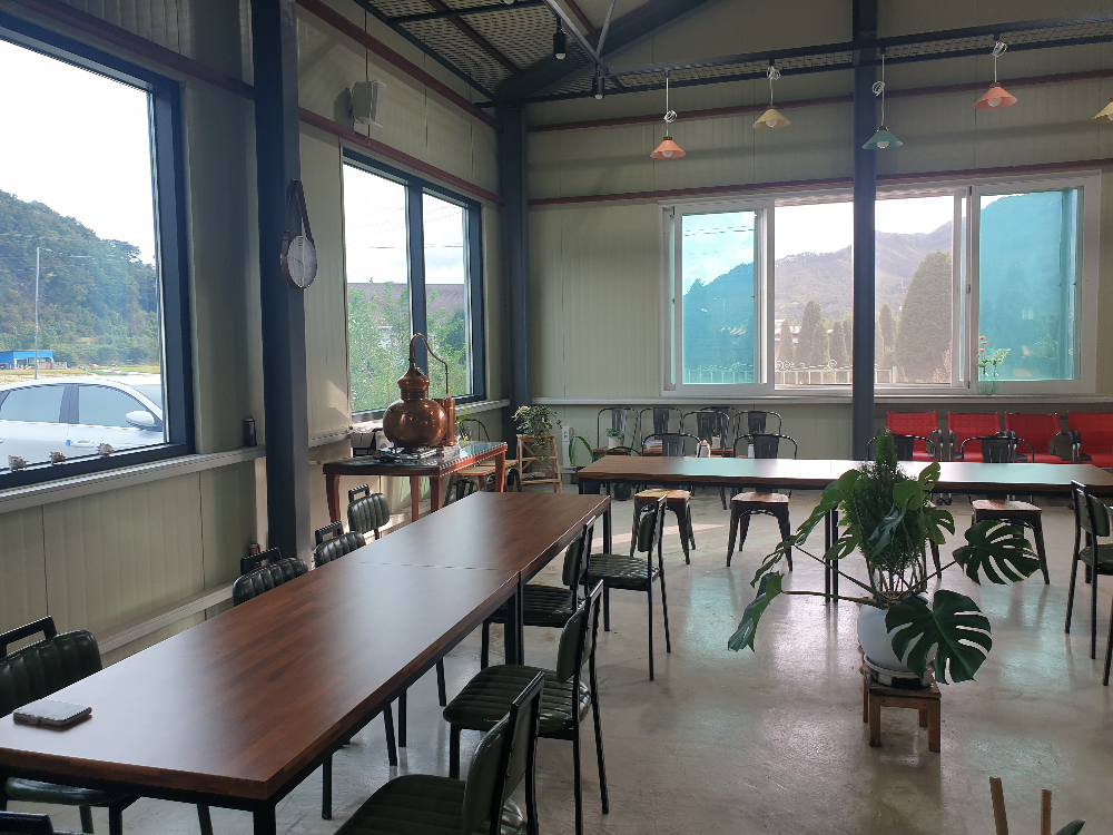 넓은 장소에 테이블이 놓여있다. 한쪽에는 소형 증류기가 보인다.